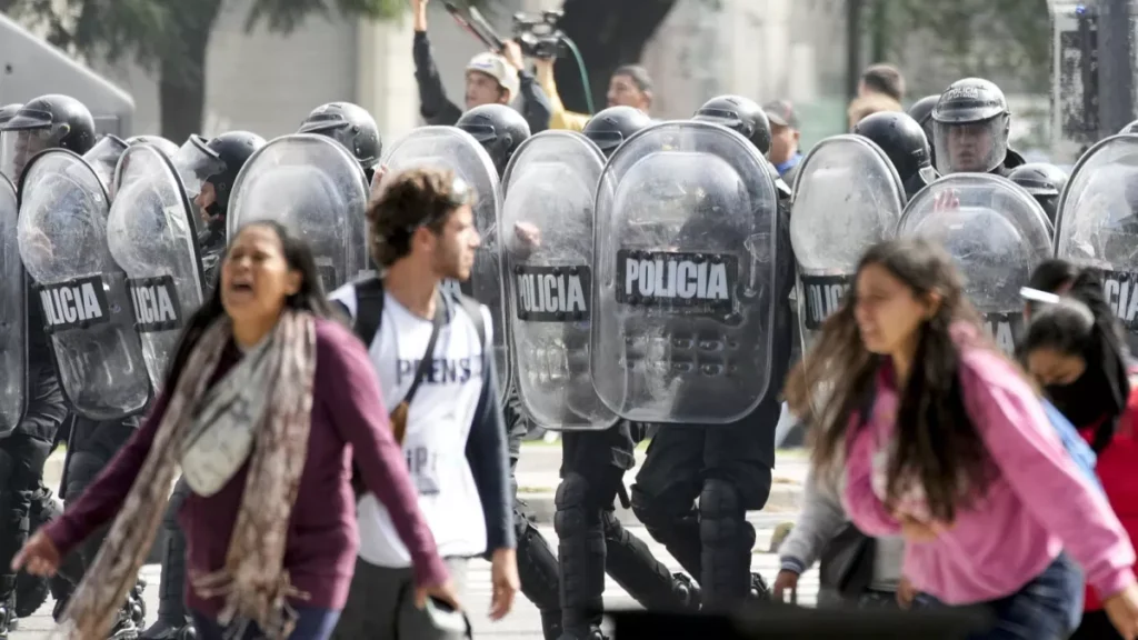 Niñas lloran escudos policia